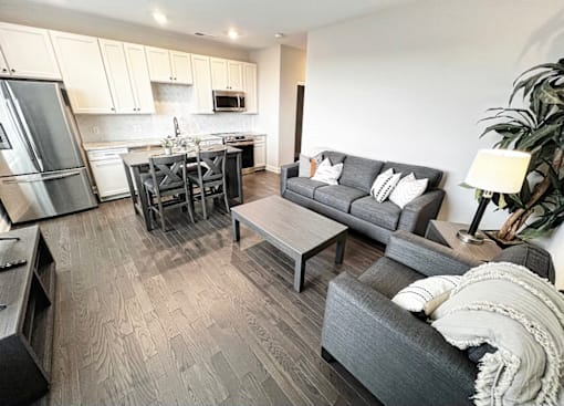 a living room with couches a coffee table and a kitchen in the background at Fairfax, Grandview, OH, 43212