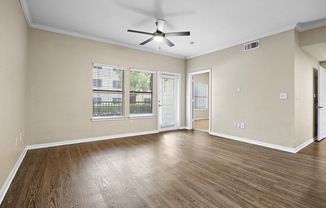 a living room with hardwood floors and a ceiling fans at Artisan Apartments & Shops