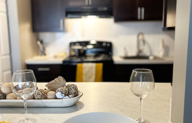 A table with a white plate and a glass of wine on it.