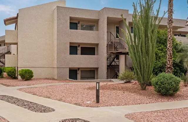 A modern building with a flat roof and a balcony on the second floor.