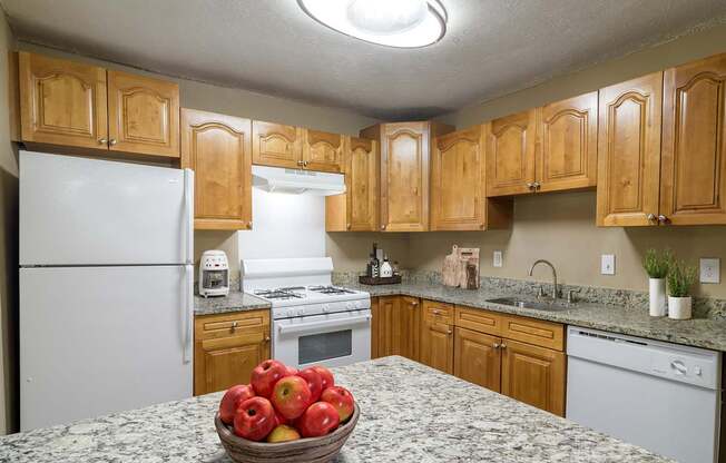 Kitchen at Stratford Ridge Apartments in Marietta, GA, showcasing warm wooden cabinets and clean white appliances, offering a bright and functional cooking space.