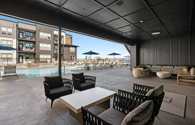 a large patio with chairs and tables and a pool