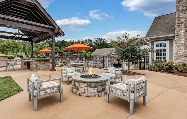 an outdoor patio with a fire pit and tables