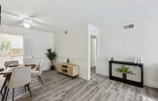 a living room and dining room with a table and chairs
