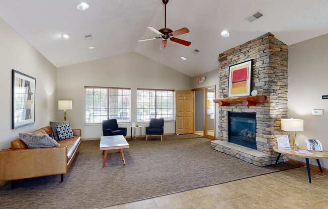 Clubhouse living room with a fireplace and a ceiling fan