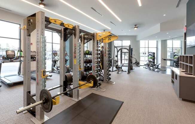 a gym with weights and other equipment in a building with windows