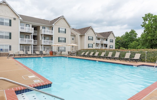 A large swimming pool in front of apartment buildings.