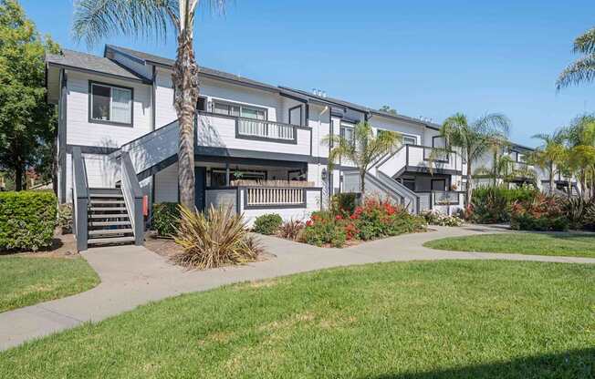 A modern apartment complex with a well-maintained lawn and landscaping.
