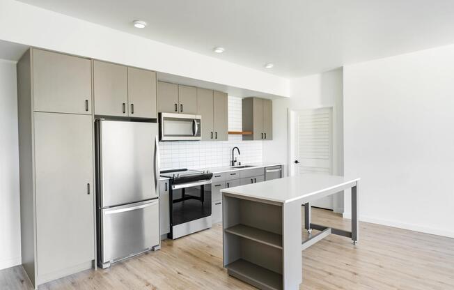 Modern kitchens feature stainless steel appliances, flat-panel cabinetry, quartz-style countertops, and a versatile movable island that adds flexibility for meal prep, dining, and entertaining.
