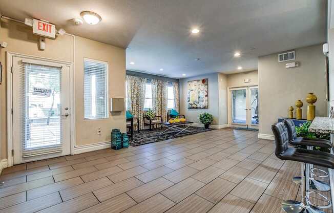 A living room with a black leather chair and a bar stool.