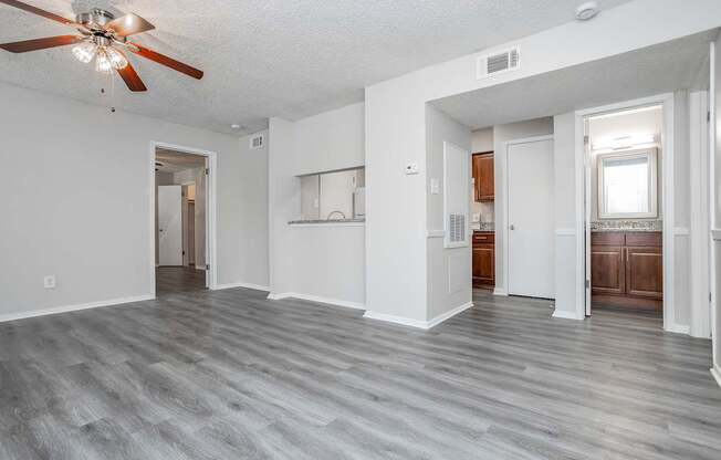 A spacious room with a ceiling fan and lighting fixture.