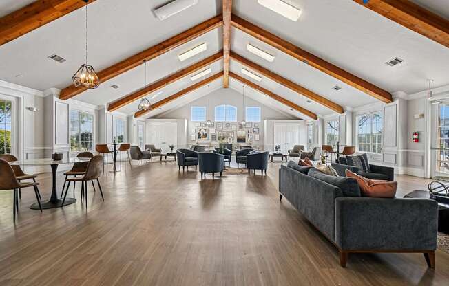 A spacious living room with a grey couch and wooden floors.