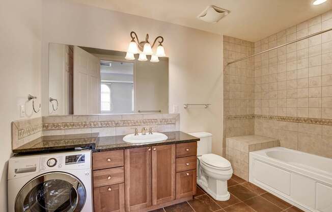 A bathroom with a washer and dryer built into the cabinetry.