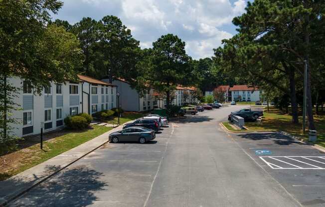 A street view of a residential area with cars parked on the side.