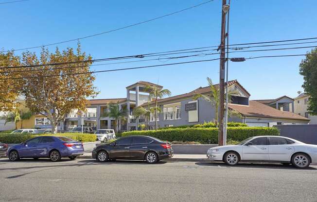 Three cars parked in a row on a street.