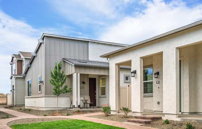A modern house with a grey exterior and a brown door.
