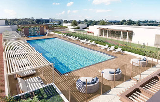 A large outdoor swimming pool surrounded by sun loungers.