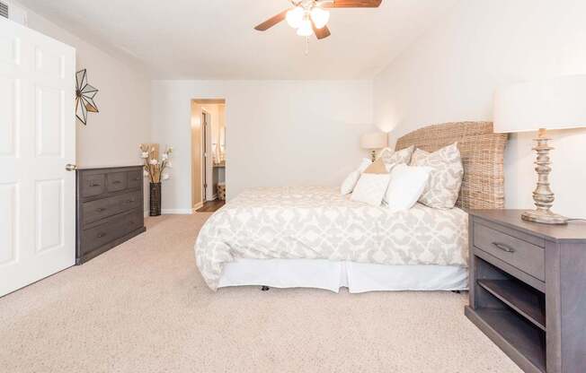 A bedroom with a large bed and a ceiling fan.