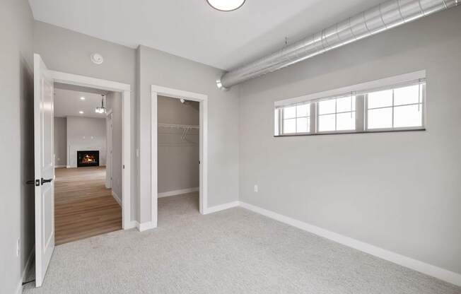 A spacious room with a fireplace and a window.