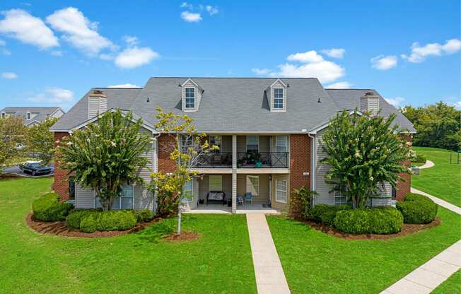 a house with a lawn and trees in front of it