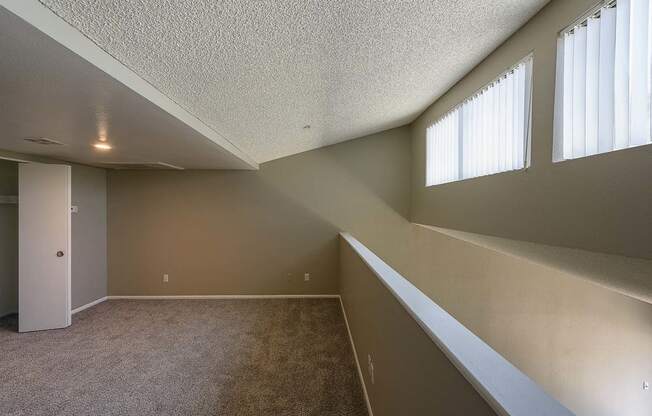 a large empty room with windows and a ceiling