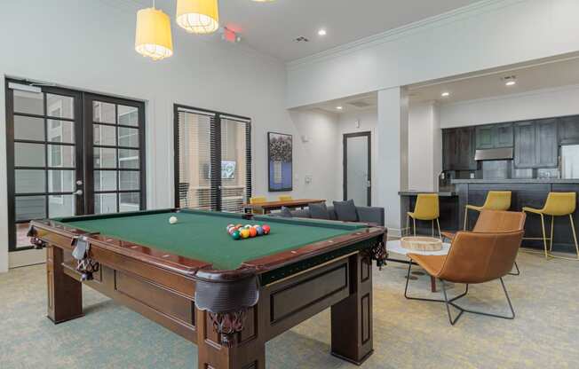 a community room with a pool table and chairs