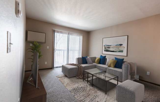 Grand Forks, ND Library Lane Apartments a living room with a gray couch and a coffee table with a glass sliding door