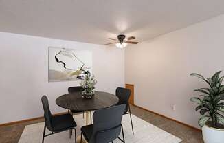 a dining room with a table and chairs and a ceiling fan. Fargo, ND Schrock Apartments