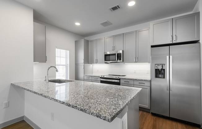 a kitchen with a granite counter top and stainless steel refrigerator