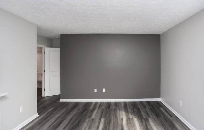 A room with a wooden floor and a white door.
