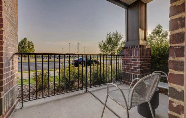 a balcony with two chairs and a fireplace and a parking lot