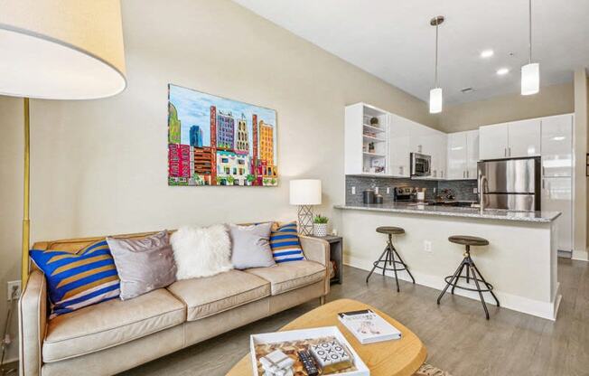 a living room with a couch and a kitchen at Link Apartments Innovation Quarter, Winston Salem, NC