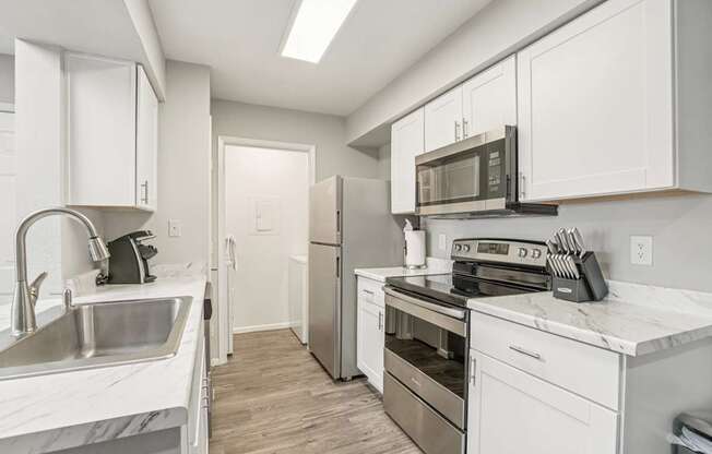 A kitchen with white cabinets and stainless steel appliances.