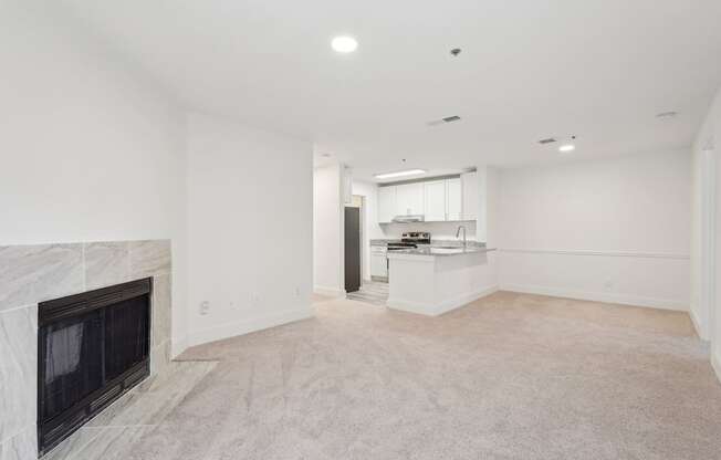 A large living room with fireplace and dining room with view of kitchen