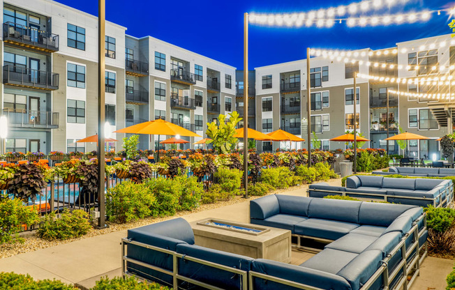 an outdoor patio with lounge chairs and umbrellas at night