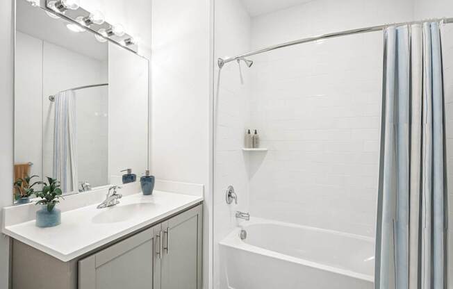 A white bathroom with a white tub and a white sink.