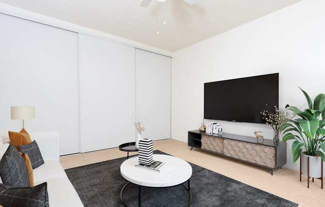 a living room with white walls and a large television