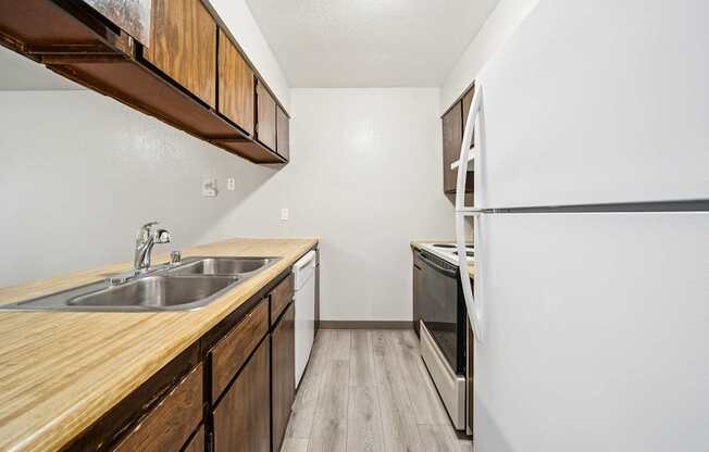 A kitchen with a wooden counter top and stainless steel appliances.