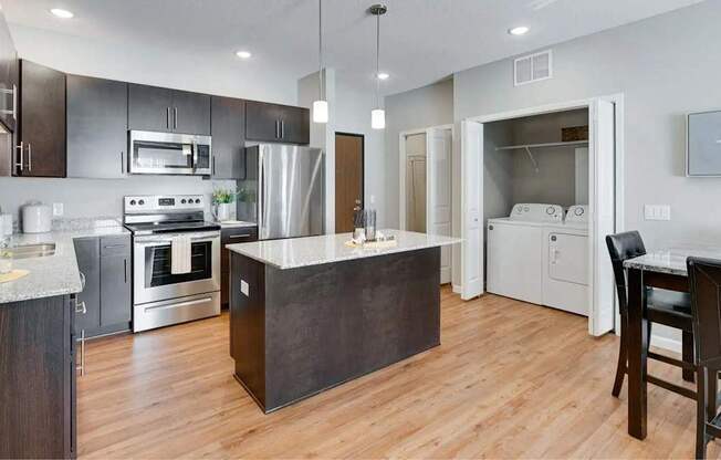 an open kitchen with a large island in the middle. Circle Pines, MN Lexington Lofts