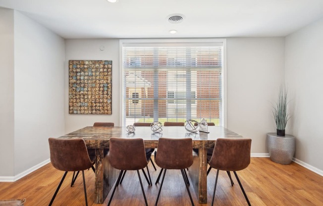 a dining room with a table and chairs and a window