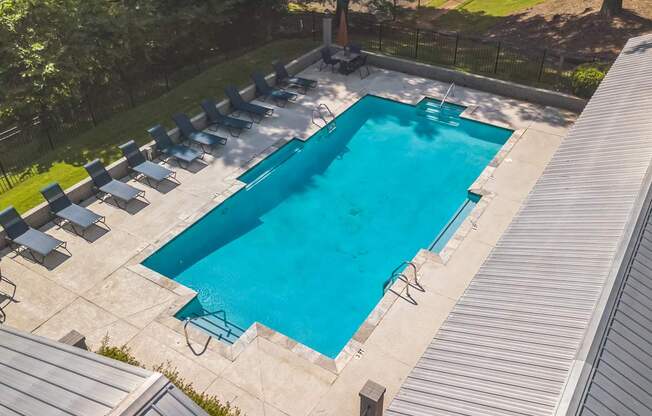 A large outdoor swimming pool surrounded by lounge chairs.