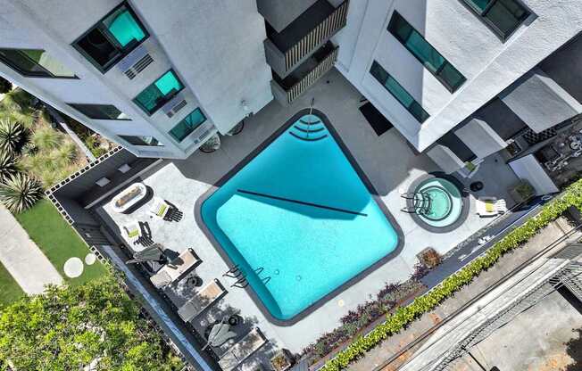 A swimming pool is surrounded by a concrete building.