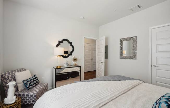 Bedroom with a bed and a chair and a mirror  at The Meadows, Bloomingdale, GA, 31302