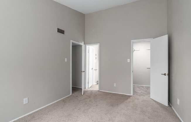 a bedroom with a carpeted floor and a door to a closet