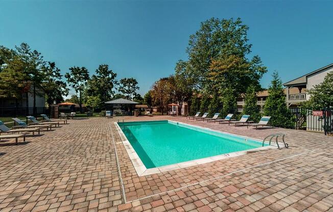 A rectangular pool surrounded by a brick patio.