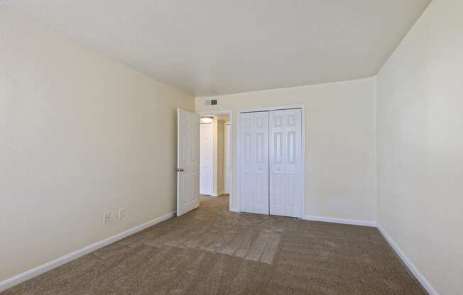 a spacious living room with carpeting and white walls