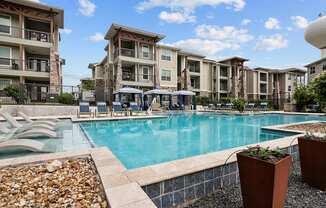 a swimming pool with an apartment building in the background