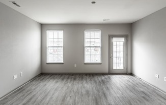 the living room of a new home with white walls and wood floors