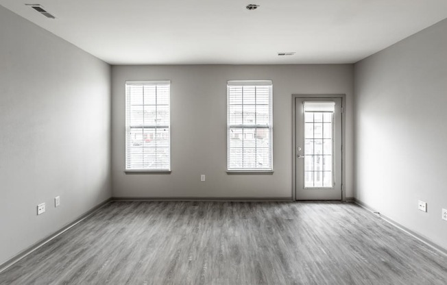 the living room of a new home with white walls and wood floors