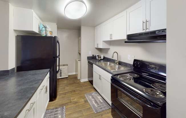 a kitchen with white cabinets and black appliances